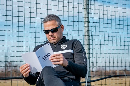 Allenatore americano legge il programma YWC a bordo campo